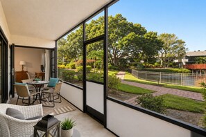 A balcony with a view of a landscaped garden, outdoor furniture, and a pathway. - Park Shore Resort-Deluxe Condo 1st FloorBLDGE #134 (Park Shore Resort)