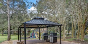 A covered pavilion with a playground, barbecue grills, and trees. - Bahama Bay SPECTACULAR Penthouse Lilo and Stitch (Davenport)