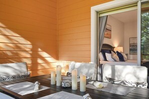 Una habitación con paneles de madera, una cama, una mesa con velas y vistas por una ventana.