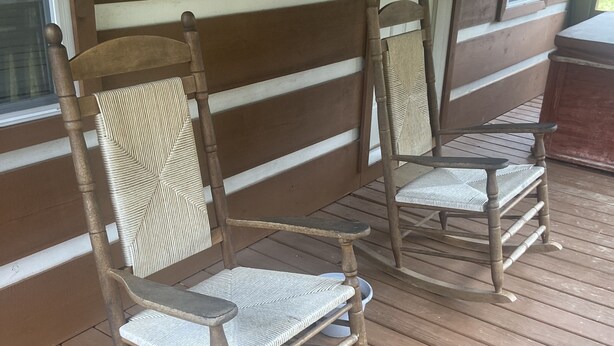 Two rocking chairs on a wooden porch with a view of the surrounding area. - Beautiful Cabin Nestled in the Smokies (Hartford)