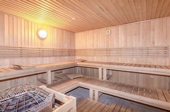 Una sauna con bancos de madera y techo inclinado.