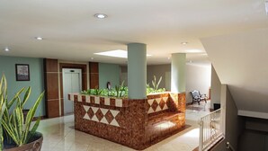 A lobby with a reception desk, a staircase, and a seating area. - Hotel San Juan (Villahermosa)