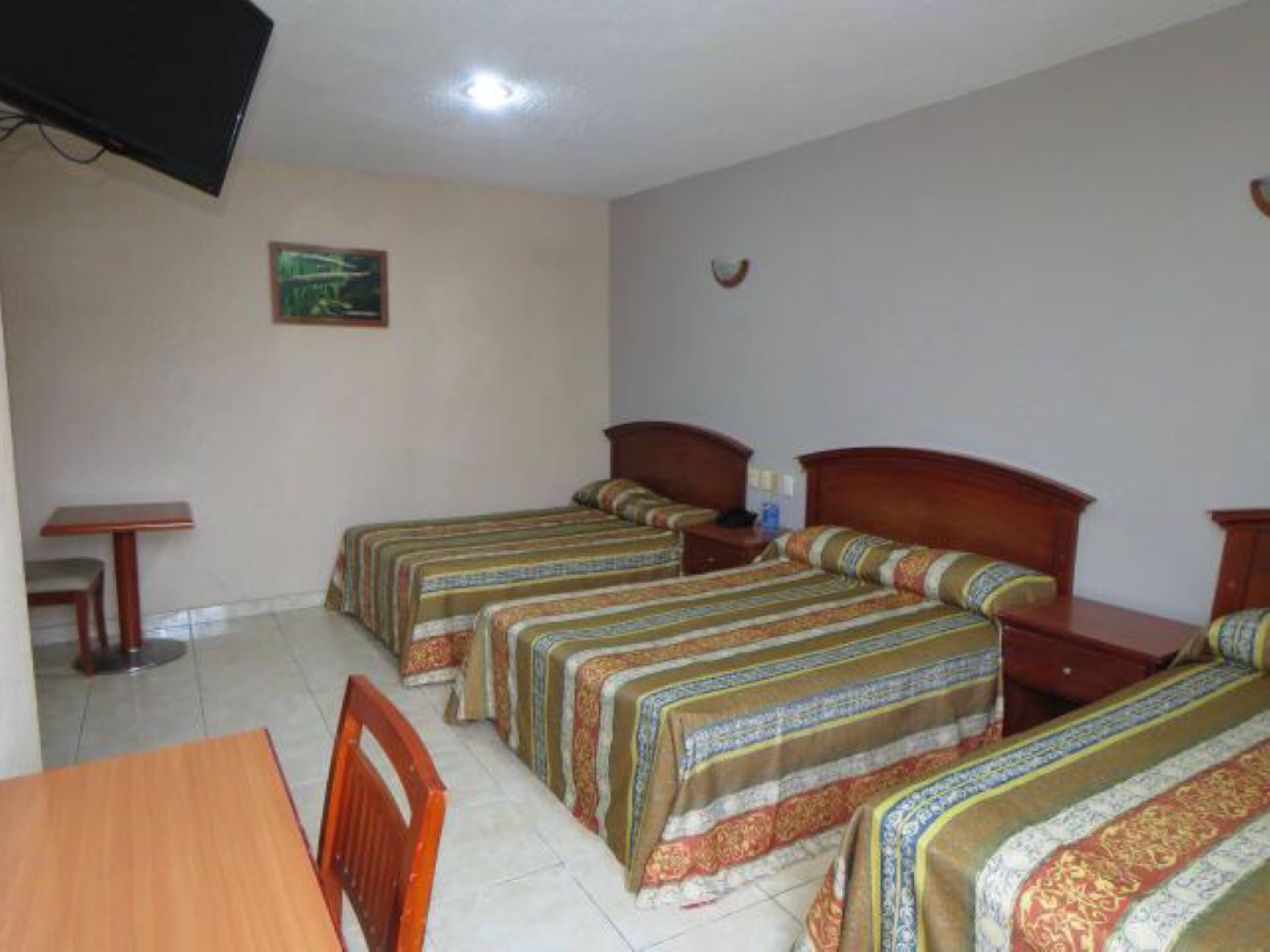 Una habitación de hotel con dos camas individuales, un escritorio de madera y una silla.