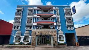 A multi-story building with a blue facade, multiple balconies, and a sign indicating it is a hotel. - Hotel San Juan (Villahermosa)