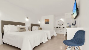 Una habitación de hotel con dos camas, un escritorio, una silla y un televisor.