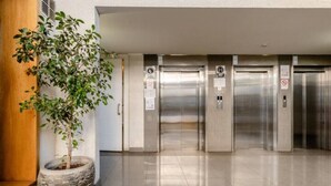 An elevator area with a potted plant and a tiled floor. - A2 lindo y comodo 2D 2 B full equipado hasta 6 pax metro en la puerta (Santiago)