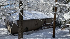 A snow-covered wooden cabin with a star decoration on the door, surrounded by trees. - Secluded Cabin w/ HOT TUB, Woodburning Stove, VIEW on PRIVATE 2 acres (Cosby)