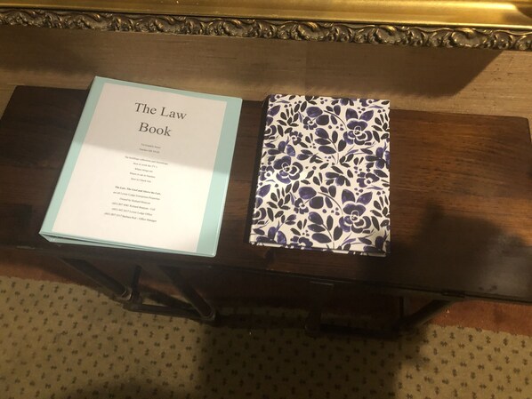 A book titled "The Law Book" and a patterned notebook on a wooden table. - The Law Building (Natchez)