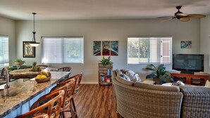 A spacious living area with a dining table, wicker furniture, and a ceiling fan. - Kimo's Getaway (Kailua-Kona)