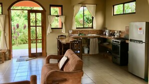 Une cuisine spacieuse avec un coin repas, un canapé et une vue sur le jardin.