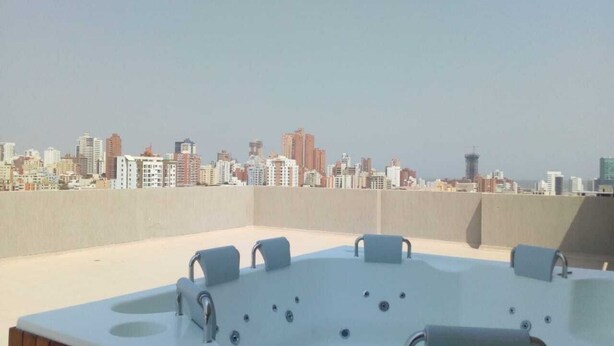 A rooftop jacuzzi with a city skyline view.