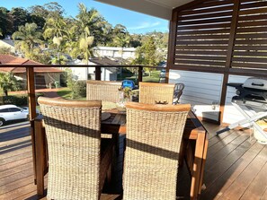 A covered outdoor area with wicker furniture, a table, and a grill. - 1 Hour from Sydney 500 meters to Terrigal beach, restaurants and night life. (Terrigal)