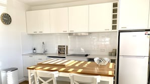 A modern kitchen with white cabinets, a wooden countertop, and a stainless steel sink. - 1 Hour from Sydney 500 meters to Terrigal beach, restaurants and night life. (Terrigal)