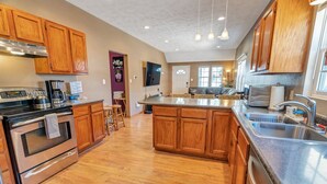 Une cuisine moderne avec des meubles en bois, des appareils en acier inoxydable et un îlot central.