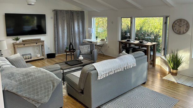 En moderne stue med sofa, TV og spiseplads.