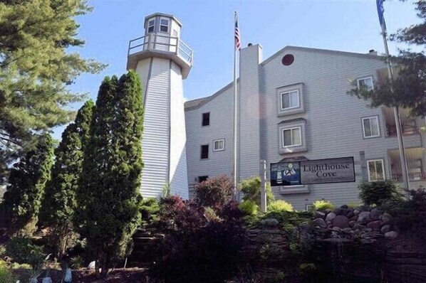 A building with a lighthouse tower and a sign that reads "Lighthouse Cove."