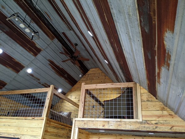 A rustic wooden structure with a sloped roof and a ceiling fan. - Faye's Retreat (Fort Payne)