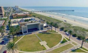 Ein Küstenhotel mit Innenhof, Blick auf den Strand und einem Pier im Hintergrund.