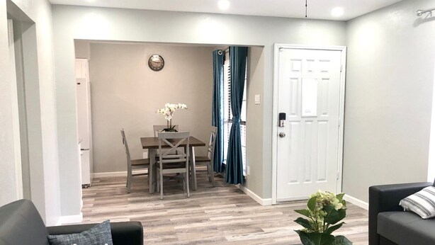 A modern living room with a sofa, a coffee table, and a dining area with a table and chairs. - Central Frisco-Full renovated cozy&nice half duplex 3bed|2bath free wifi&parking (Frisco)