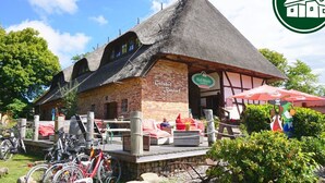 A traditional thatched-roof building with a sign reading "Cutshof." - Gutshof Superior Studios II - Gutshof Bastorf/ Urlaub an der Ostsee in Mecklenburg (Bastorf)