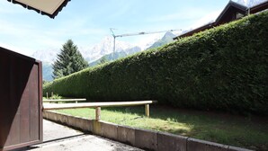 Un sentier menant à un bâtiment d’où l’on peut admirer des montagnes enneigées.