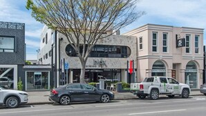 A street view with a building labeled 'blax' and a 'green acres' truck parked on the sidewalk.