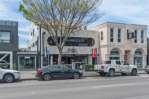 A street view with a building labeled 'blax' and a 'green acres' truck parked on the sidewalk.