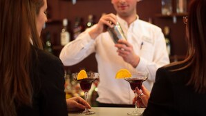 Un bar con un cantinero preparando bebidas.