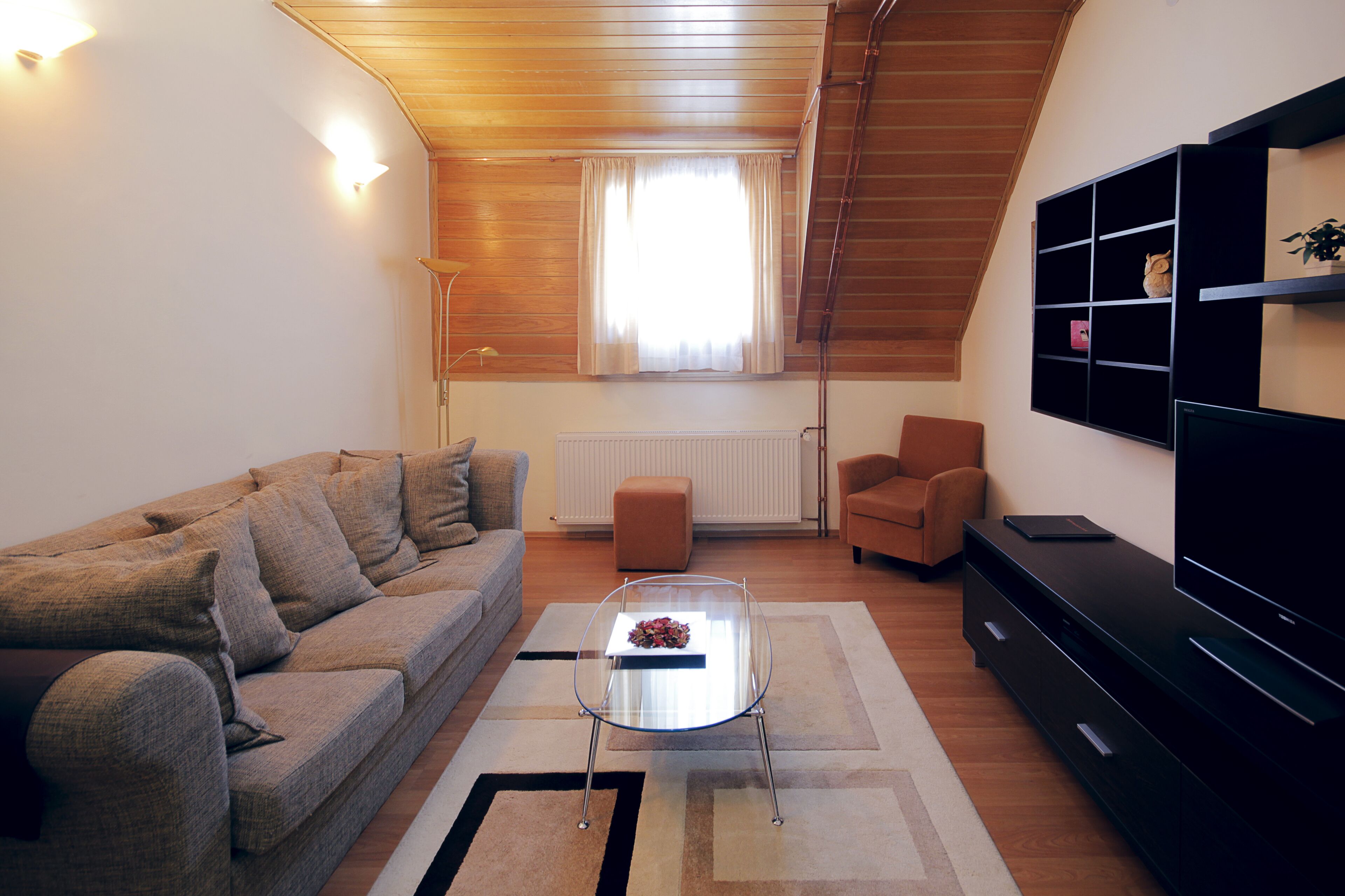 Uma sala de estar moderna com sofá, mesa de centro e rack para TV.