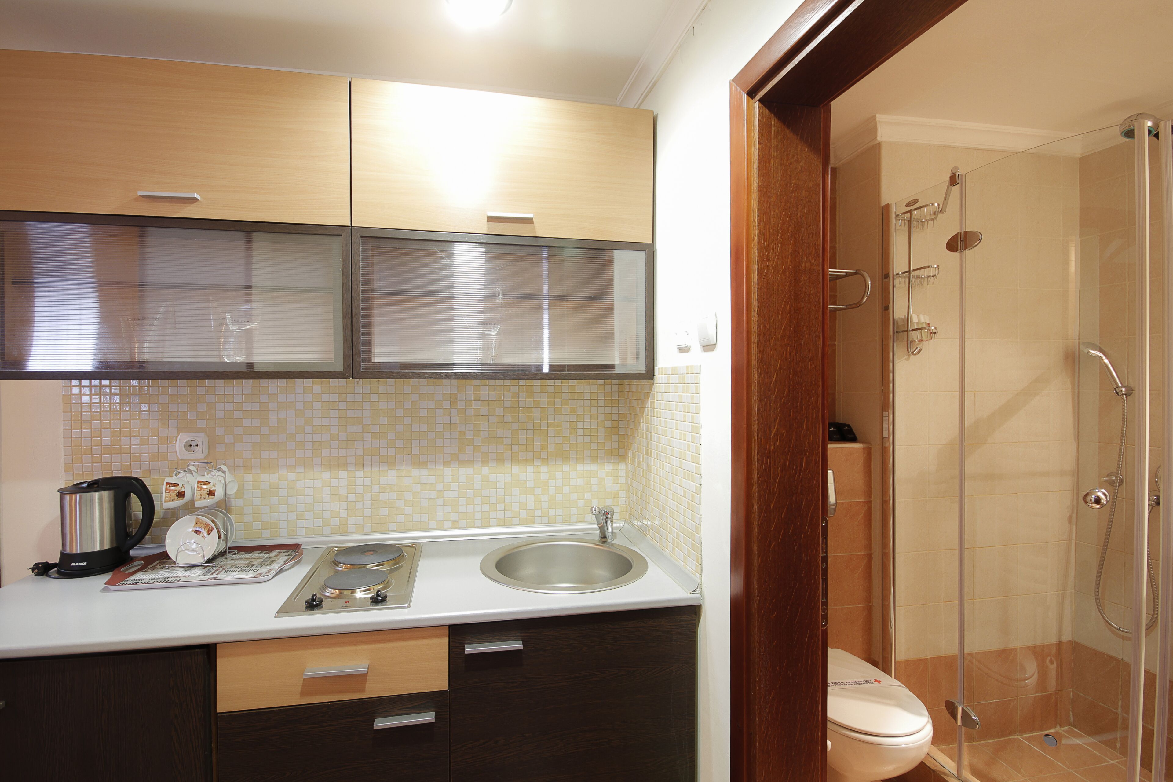 A compact kitchen with a sink, a coffee maker, and a microwave.