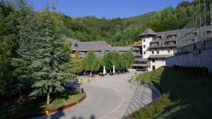Un hotel con varias edificaciones, una zona de estacionamiento y un paisaje montañoso.