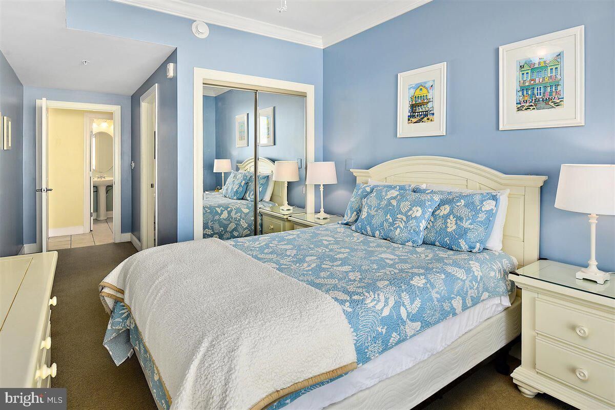 Une chambre à coucher avec un grand lit, une table de chevet, une commode et un miroir.