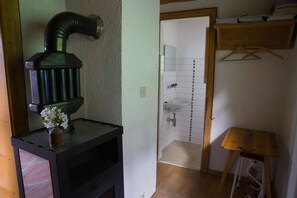 Pieni kylpyhuone, jossa on pesuallas, peili ja puinen jakkara.