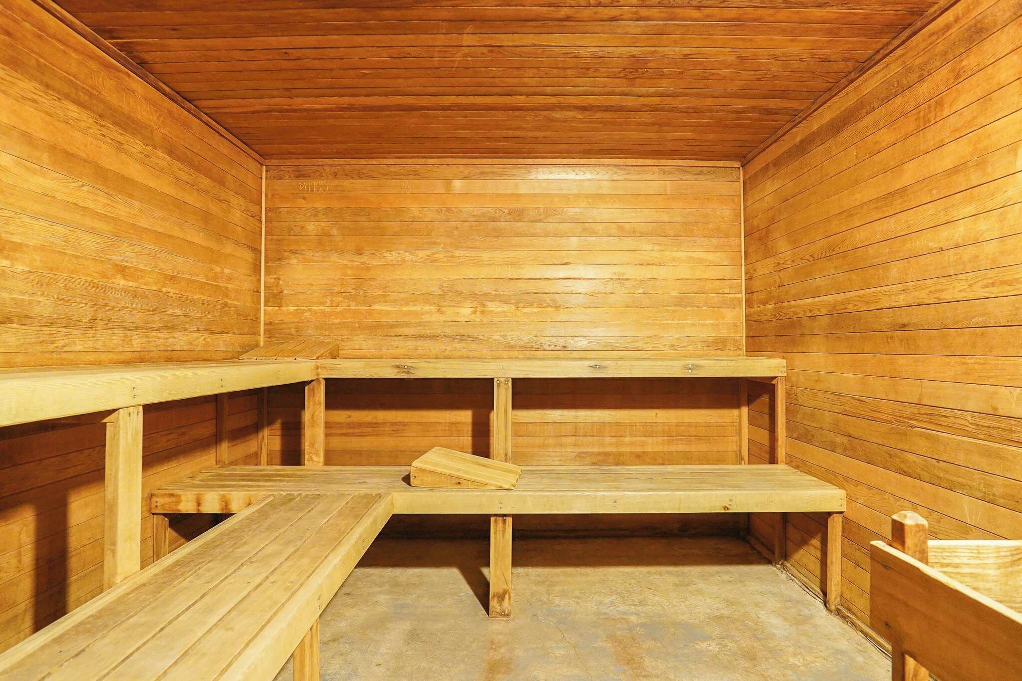 A sauna with wooden benches and a bench with a towel.