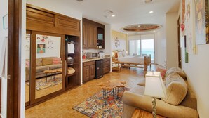 Un espacio habitable compacto con kitchenette, un sofá, un comedor y vistas al exterior.