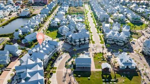 A coastal residential area with modern houses, a marina, and a beach.