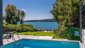 A swimming pool with a view of a lake and hills in the background. - Awesome home in Medulin (Medulin)