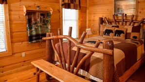 A log cabin room with a wooden bed, a quilted blanket, and a poster on the wall.