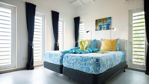 A bedroom with a bed, curtains, a painting, and a window.