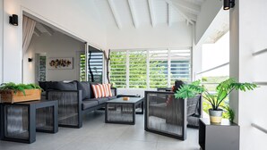 A modern living room with a grey sofa, black coffee table, and a potted plant.