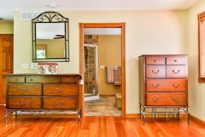 A room with wooden flooring, a dresser with drawers, a mirror, and a door leading to another room. - Catskills retreat: Hot tub, ATV, hiking & fishing (Cairo)