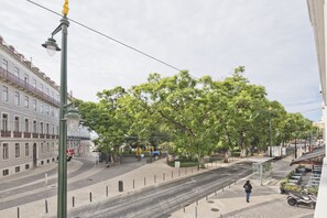 Une rue avec des voies de tramway, un passage piéton et un arrêt de tramway doté d’un abri.