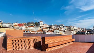 En takterrass med väggar av rött tegel och utsikt över stadsbilden.