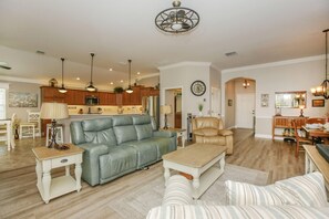 Relax in this stylish living space with a comfortable sofa, armchair, and dining area.
