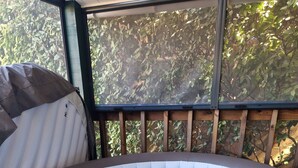 Un jacuzzi con terraza de madera y vista a árboles.