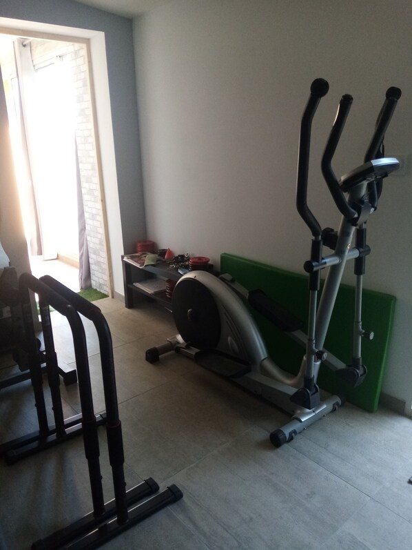 A home gym with an elliptical machine, a treadmill, and a stationary bike.