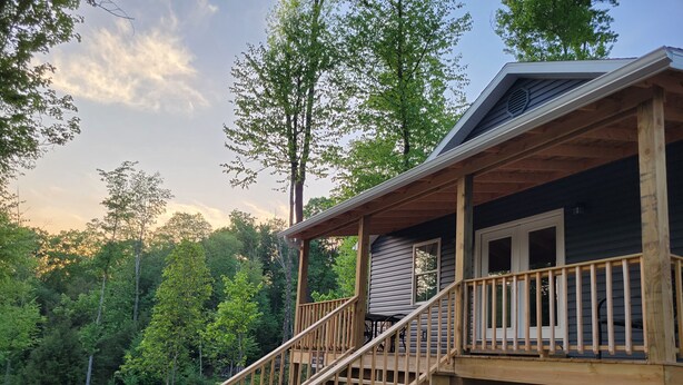 A wooden deck with a staircase leading to a covered porch. - The Wildflower Cottage at Mountain Paradise (French Creek)