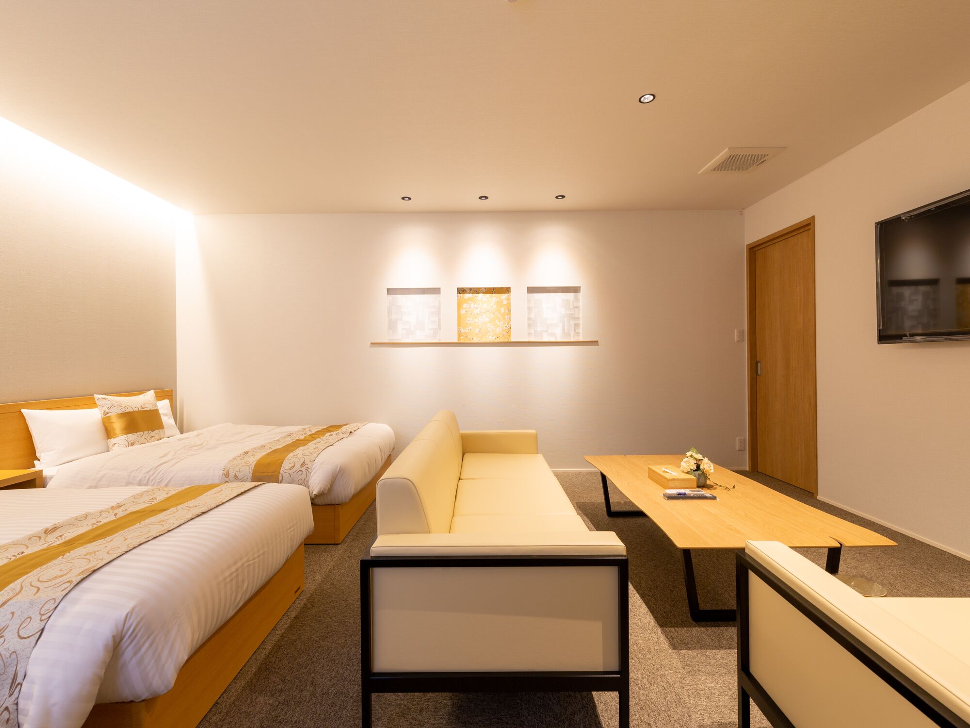 Una habitación de hotel con cama, sofá, escritorio y televisión.