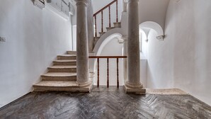 A grand staircase with classical columns, leading to an upper floor. - Apartment close to the beach and main street (Dubrovnik)