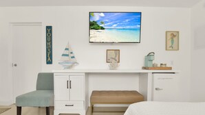 A bedroom with a bed, a desk with a computer, a chair, a small cabinet, and a framed picture of a mermaid. - Boutique Hotel Queen room w/ Bunk bed. POOL, LOCATION! Walk to BEACH/Restaurants (Deerfield Beach)